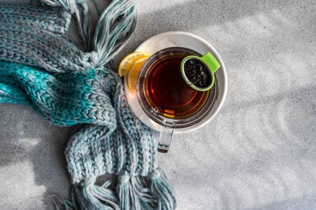 From above of cozy winter scene with a hot cup of tea and a lemon slice, accompanied by a soft, knitted scarf on a textured background Model Released AnnaBogush_ID19162_569987_005 Copyright: xAnnaxBogushx