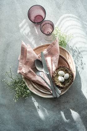 Top view elegant and simple table setting celebrates Easter with a bird s nest containing speckled eggs, surrounded by delicate china and soft pink linen. Model Released AnnaBogush_ID19406_575250_014 Copyright: xAnnaxBogushx