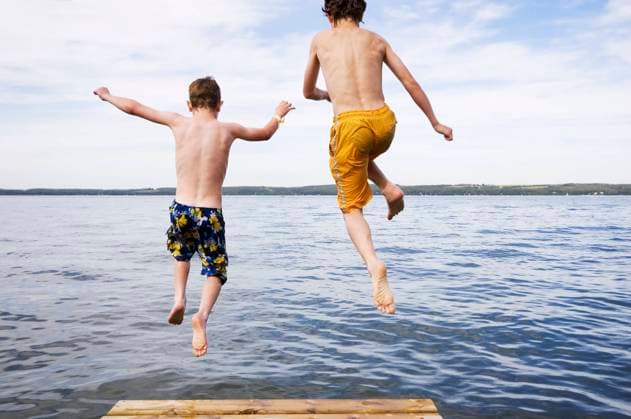 two boys (9 & 12 years old) jumping off dock into lake, Sylvan Lake, Alberta. model released MR_acp05766a, MR_acp05766c  Copyright: x AllCanadaPhotos.comx 1990-55061 ,model released, Symbolfoto