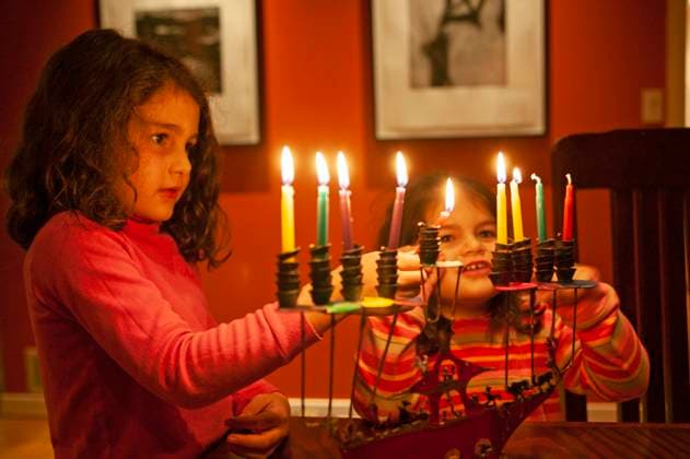 Two young girls lighting Chanukah candles during the festival of lights. Dallas TX USA  Copyright: xStewartxCohenxPicturesx 4009-111441683 ,model released, Symbolfoto ,property released