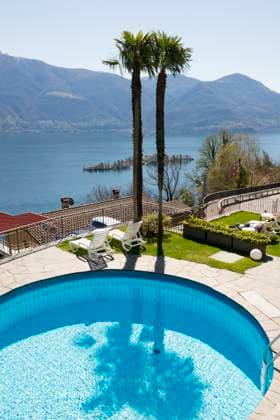 Swimming pool and palm trees over alpine lake Maggiore with Brissago Islands and mountain in Ronco sopra Ascona in Ticino, Switzerland. Ascona Ticino Switzerland  Copyright: xSodatechxAG,xSwitzerlandx 4452-20461168