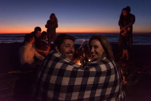 Couple enjoying with friends at sunset on the beach Young Couple enjoying with friends Around Campfire on The Beach At sunset drinking beer ,model released, Symbolfoto Copyright: xZoonar.com benisxarapovicx 12519108 ,model released, Symbolfoto ,property released