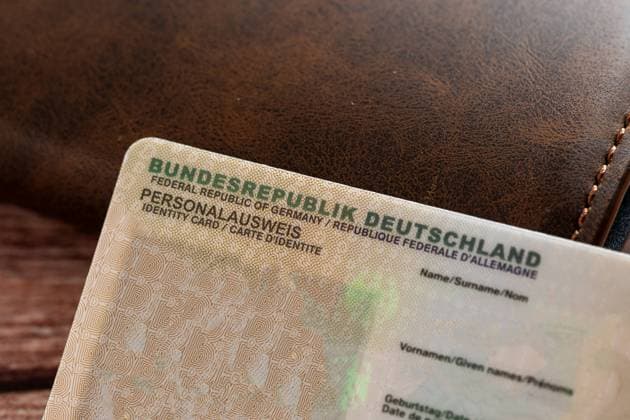 Augsburg, Bavaria, Germany - February 18, 2024: Identity card of the Federal Republic of Germany next to a wallet *** Personalausweis der Bundesrepublik Deutschland neben einem Geldbeutel