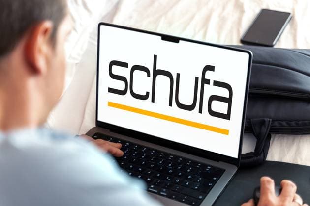 February 20, 2024: Man sitting at a laptop computer, the SCHUFA logo can be seen on the display. PHOTOMONTAGE *** Mann sitz an einem Laptop Computer, im Display ist das Logo der SCHUFA zu sehen. FOTOMONTAGE