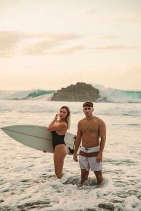 Creative Highlights Symbolbilder Couple surfing on a nice beach in Tenerife during sunset Santa Cruz de Tenerife, Canary Islands, Spain CR_AICA240205-1343414-01 ,model released, Symbolfoto