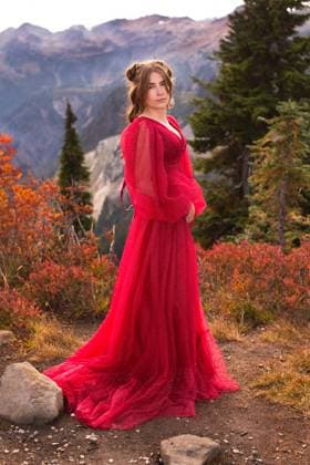 Creative Highlights Symbolbilder Strong serious woman in red gown on mountain Glacier, Washington, United States CR_REBE240215-1352028-01 ,model released, Symbolfoto