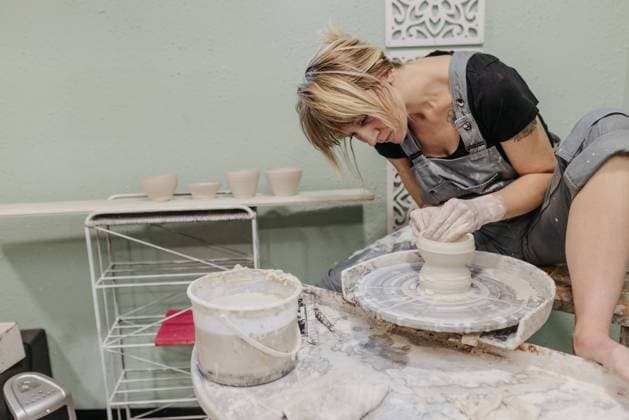 Creative Highlights Symbolbilder Woman sits at pottery wheel while throwing pots in home studio Sioux Falls, South Dakota, United States CR_ASWE240123-1328632-01 ,model released, Symbolfoto ,property released