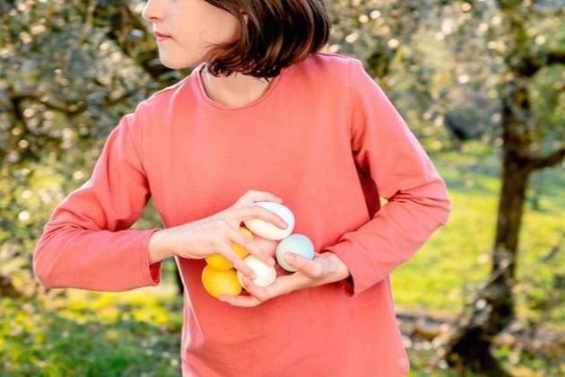 Girl with a handful of dyed easter eggs in orchard, mid section, Scandicci, Tuscany, Italy Tuscany Italy Copyright: xx
