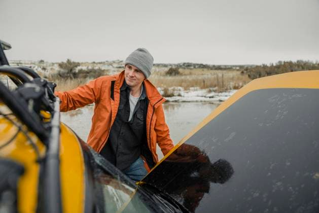 Creative Highlights Symbolbilder A Caucasian young male holds onto his SUV stranded in a puddle. Menan, Idaho, United States CR_OUNO240225-1356351-01 ,model released, Symbolfoto ,property released
