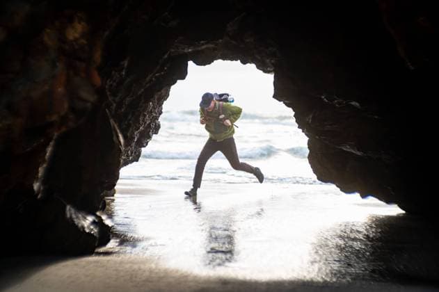 Creative Highlights Symbolbilder Person running from waves at beach holding onto backpack Pescadero, California, United States CR_CHEREN240227-1338725-01 ,model released, Symbolfoto