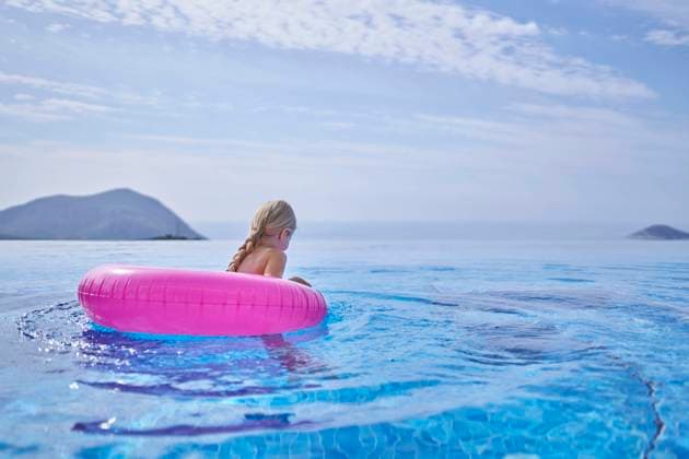 Girl swimming with inflatable tube in blue pool model released, Symbolfoto property released, ANNF00810