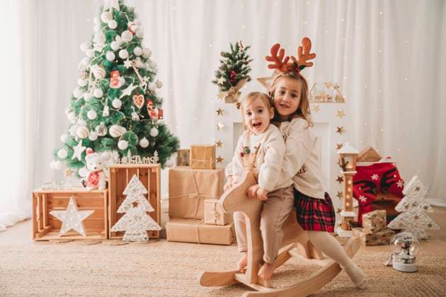 Happy sisters sitting together on rocking horse at home model released, Symbolfoto property released, EBBF08321