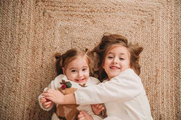 Happy sisters lying on carpet at home model released, Symbolfoto property released, EBBF08336