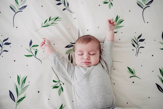 Creative Highlights Symbolbilder Cute baby girl stretching arms lying in bed at home model released, Symbolfoto property released, EBBF08434