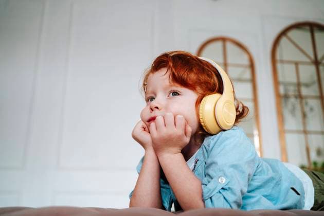 Creative Highlights Symbolbilder Redhead boy listening music through wireless headphones at home model released, Symbolfoto property released, MDOF01797