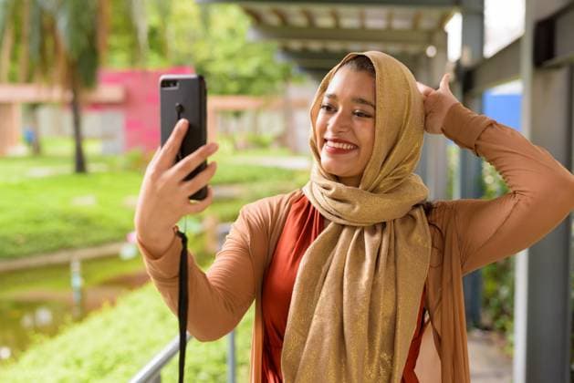 Happy young beautiful Indian Muslim woman taking selfie at the park Portrait of young beautiful Indian Muslim woman with hijab relaxing at the park outdoors ,model released, Symbolfoto Copyright: xZoonar.com TonixRantalax 16100517 ,model released, Symbolfoto ,property released