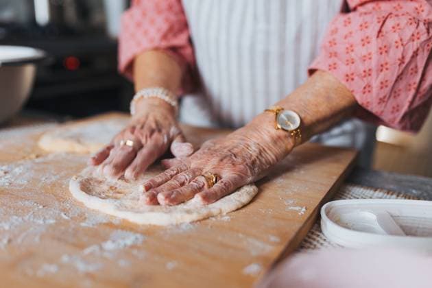Close up of hands of senior woman preparing traditional easter meals for family, kneading dough for easter cross buns. Recreating family recipes, custom. Close up of hands of senior woman preparing traditional easter meals for family, kneading dough for easter cross buns. Recreating family recipes, custom. Concept of easter holidays and traditions. model released
