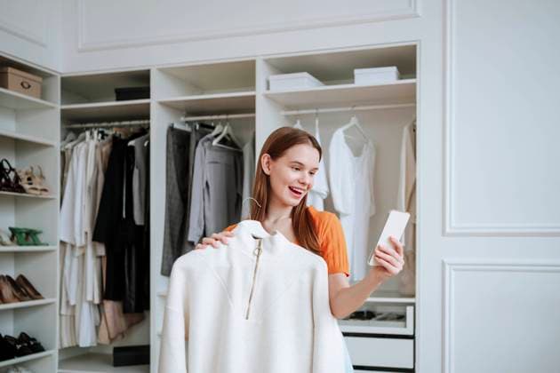 Creative Highlights Symbolbilder Happy woman talking on video call near closet at home model released, Symbolfoto property released, NLAF00373