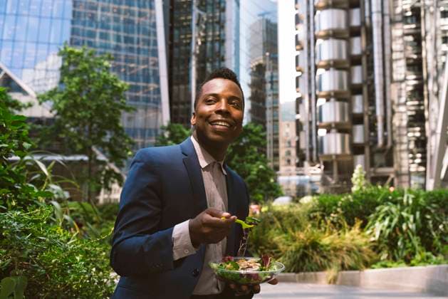 Happy mature businessman sitting with bowl of salad at office park model released, Symbolfoto, OIPF03820
