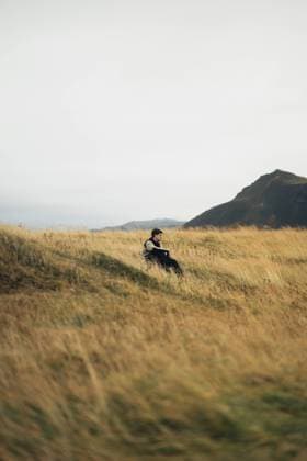 Creative Highlights Symbolbilder A lone man seated in a peaceful meadow, with the rolling hills of Iceland in the background. Model Released AlbertoOrtega_ID19187_570985_089 Copyright: xAlbertoxOrtegax