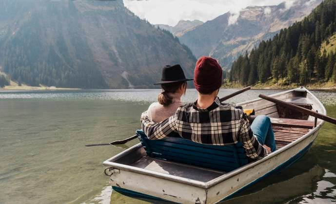 Young couple sitting in boat at lake Vilsalpsee near mountains, Tyrol, Austria model released, Symbolfoto, UUF31090