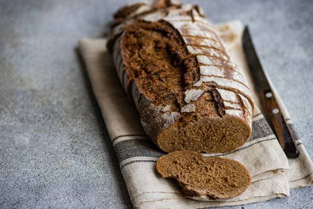 Sliced rye sourdough bread on a beige cloth with a knife, showcasing its airy crumb and crusty exterior Model Released AnnaBogush_ID19733_585089_009 Copyright: xAnnaxBogushx