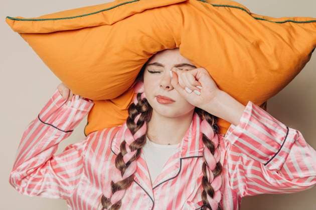 Creative Highlights Symbolbilder Tired woman with pillow over head standing near wall model released, Symbolfoto, VSNF01639