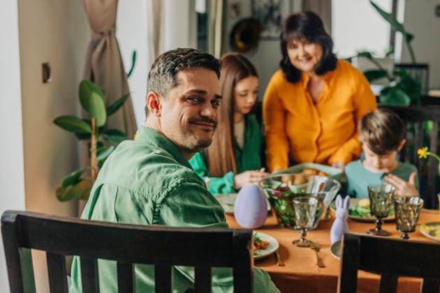 Smiling man looking over shoulder at Easter dinner with family model released, Symbolfoto, VSNF01654