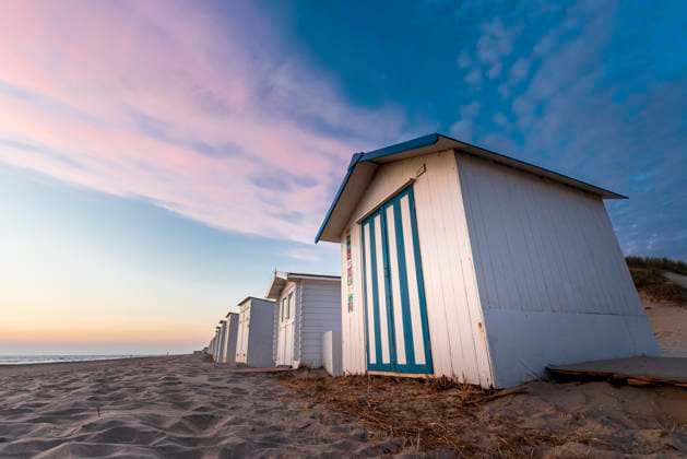 Abendstimmung mit Blick auf weiße Strandhütten mit blauen Streifen am Meer unter rosa Wolkenhimmel, Texel, Nordsee, Niederlande, Europa *** Abendstimmung with View at Whites Beach huts with blue Strip on Sea at Pink Cloudy sky, Texel, North Sea, Netherlands, Europe Copyright: imageBROKER MarkusxQuabach iblmqu05065740.jpg RECORD DATE NOT STATED