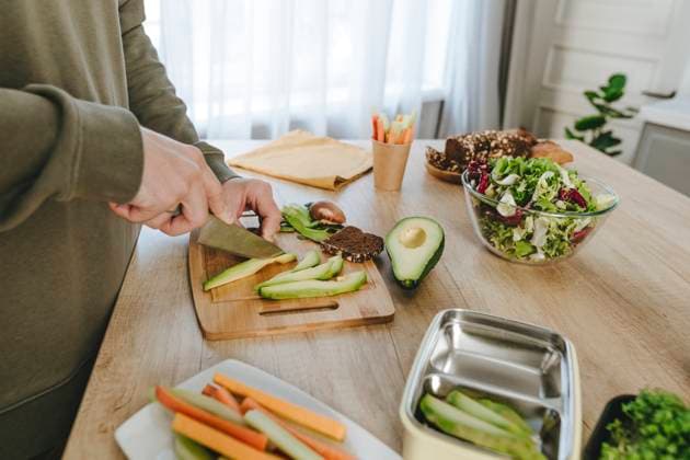 IMAGO Creative, Food, Trend, Meal Prep Man cutting avocado with knife in kitchen at home model released, Symbolfoto property released, YTF01680