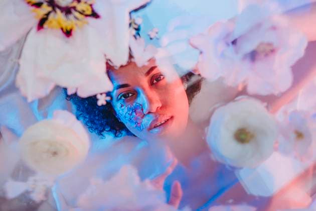 Creative Highlights Symbolbilder Beautiful woman lying behind glass surface with flowers model released, Symbolfoto, YTF01701