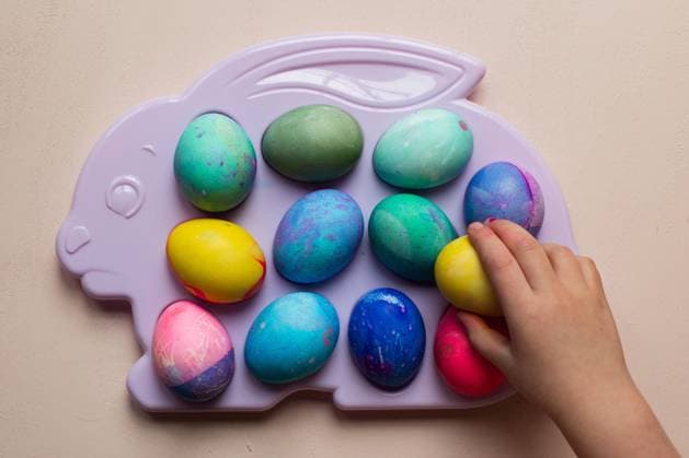 Creative Highlights Symbolbilder Child reaching for dyed Easter eggs on a plastic tray Seattle, Washington, United States CR_AAGC240229-1359986-01 ,model released, Symbolfoto
