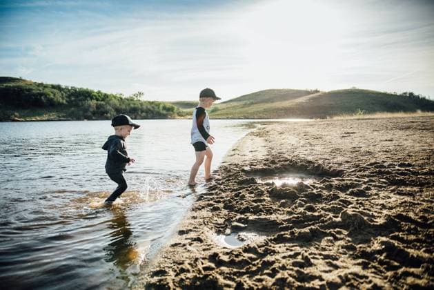 Side view of two young boys playing in a lake on a summer evening. Bismarck, North Dakota, United States CR_KIFR240228-1358305-01 ,model released, Symbolfoto