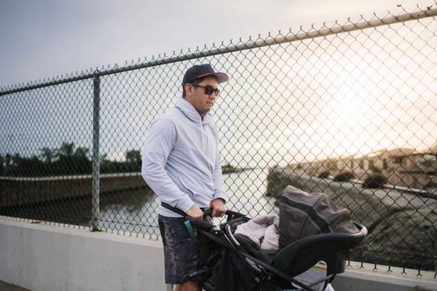 Man with hat and sunglasses pushing baby in stroller on bridge Huntington Beach, California, United States CR_RASI240229-1360441-01 ,model released, Symbolfoto