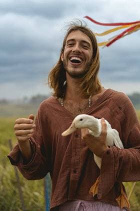 Creative Highlights Symbolbilder Smiling long-haired man holds duck in his hands. Kuta Utara, Bali, Indonesia CR_YUKI240303-1362044-01 ,model released, Symbolfoto
