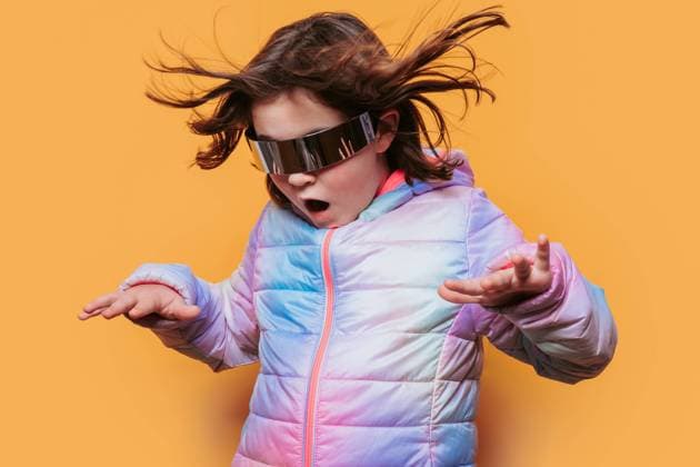 Creative Highlights Symbolbilder Child in awe with hair flying, wearing sleek futuristic glasses and a colorful jacket against an orange background Model Released HodeiUnzueta_ID19902_590020_009 Copyright: xHodeixUnzuetax RECORD DATE NOT STATED