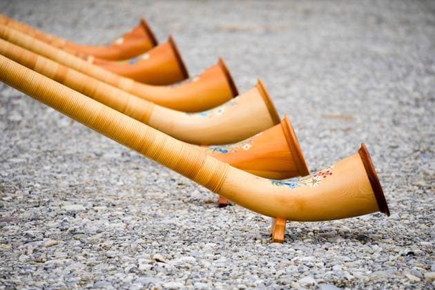 Türkheim, Bavaria, Germany - March 4, 2024: A series of alphorns made of wood in Bavaria with beautiful decorations are blown or played.Musical concept with rustic and traditional instruments.Musical concept with rustic and traditional instruments Musical concept with rustic and traditional instruments *** Eine Reihe Alphörner aus Holz in Bayern mit schönen Verzierungen werden geblasen bzw. gespielt. Musikalisches Konzept mit urigen und traditionellen Instrumenten