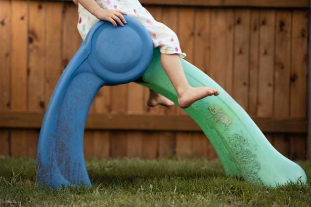 Creative Highlights Symbolbilder Toddler Girl Sliding Down Toy Slide In Backyard Tulsa, Oklahoma, United States R_XBCB240228-1359883-01 ,model released, Symbolfoto