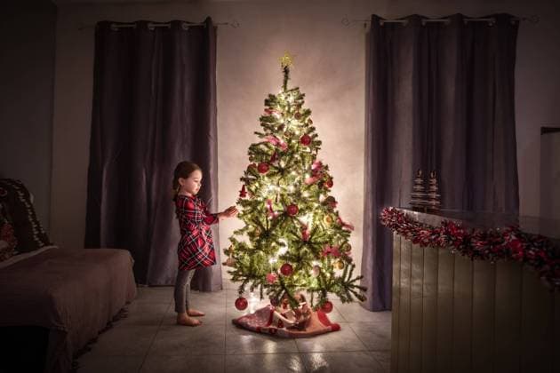 Creative Highlights Symbolbilder Little girl places ornament on the Christmas tree Béziers, Occitanie, France CR_JIBA240309-1366190-01 ,model released, Symbolfoto