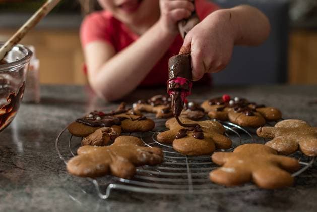 Girl pipes chocolate frosting onto Christmas cookies while baking Béziers, Occitanie, France CR_JIBA240309-1366191-01 ,model released, Symbolfoto