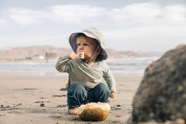 Creative Highlights Symbolbilder A young boy eats fresh coconut on the beach. Todos Santos, Baja California Sur, Mexico CR_XICZ240306-1221983-01 ,model released, Symbolfoto