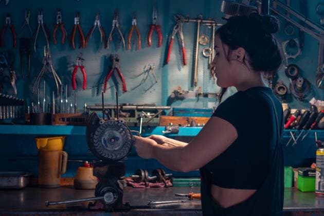 Gemischtrassige hispanische junge Mechanikerin, trägt schwarzen Overall, konzentriert sich auf ein Motorradteil in einer Werkstatt mit einem Werkzeugschrank, eine komplette Werkzeugtafel im Hintergrund mit Bokeh Effekt, traditionelle Männerberufe von gemischtrassiger Latino Frau *** multiracial Hispanic Boy Mechanic, carries Black people Overall, concentrated itself at a Motorcycle part in a Workshop with a Tool cabinet, a complete Tool panel at Background with bokeh Effect, traditional Male professions from multiracial Latino Woman Copyright: imageBROKER/Columbo ibxaug10321166.jpg ,model released, Symbolfoto ,property released 