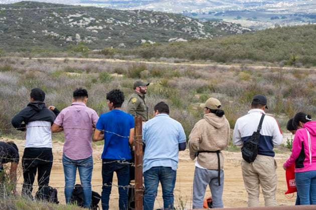 Migrants surrender to the U.S. Border Patrol after crossing the border wall from Mexico near Campo, California, about 50 miles from San Diego, on Wednesday, March 13, 2024. A bipartisan Senate immigration bill to address the migrant immigration issue is stalled in the House due to election year politics.  CAL2024031355 PATxBENIC