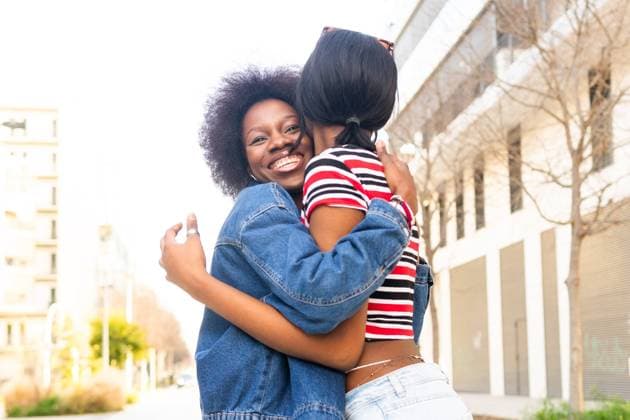 Creative Highlights Symbolbilder The genuine happiness of two sisters is captured in a warm, loving embrace on a sunlit city sidewalk, radiating familial love Model Released DavidMunoz_ID19789_587122_023 Copyright: xDavidxMunozx