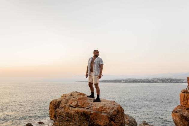 Creative Highlights Symbolbilder A man stands thoughtfully on a rocky cliff, overlooking the vast ocean as the evening sky softly fades to twilight Model Released EduardoGavira_ID19719_584800_009 Copyright: xEduardoxGavirax RECORD DATE NOT STATED