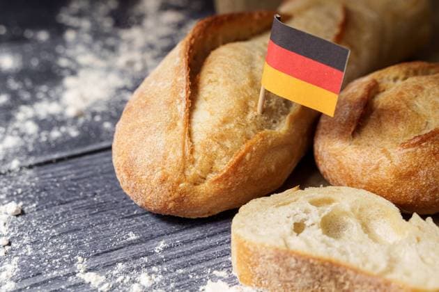 Augsburg, Bavaria, Germany - March 16, 2024: freshly baked rustic baguette bread with a Germany flag. Symbolic image of bread and baked goods made in Germany *** frisch gebackenes rustikales Baguette Brot mit einer Deutschland Fahne. Symbolbild Brot und Backwaren aus deutscher Herstellung