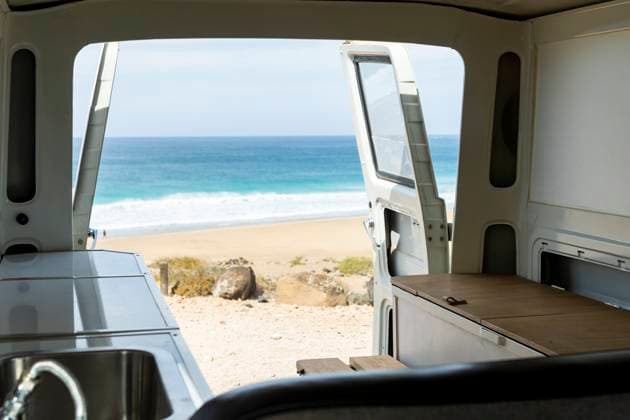 Experience tranquility through the open back of a vintage van overlooking a serene beach scene. Model Released JuanAizpuru_ID19709_584436_003 Copyright: xJuanxAizpurux