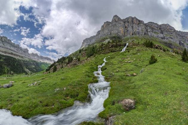 Lush greenery and a vibrant mountain stream cascade down the rocky landscape of Valle de Ordesa, located in the Ordesa y Monte Perdido National Park Model Released JuanLopez_ID19920_590360_011 Copyright: xJuanxLopezx