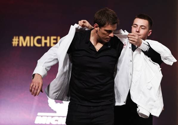 (240319) -- TOURS, March 19, 2024 -- French chef Fabien Ferre changes his new chef jacket after being awarded a third Michelin star during the Michelin Guide for France 2024 awards ceremony in Tours, France, March 18, 2024. The Michelin Guide launched its 2024 France edition on Monday in Tours. ) FRANCE-TOURS-MICHELIN GUIDE GaoxJing 