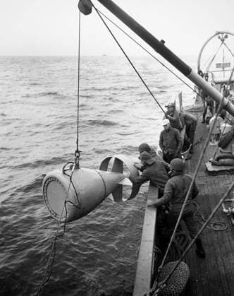 KOREAN WAR: U.S. NAVY, 1953. U.S. Navy crewmen move an acoustic detonator over the side of a minesweeper during operations off the coast of Korea, February 1953.  Copyright: xGRANGERx xGRANGERx 0034592